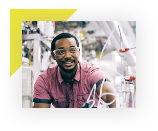 Worker wearing safety glasses, in a laboratory and smiling 